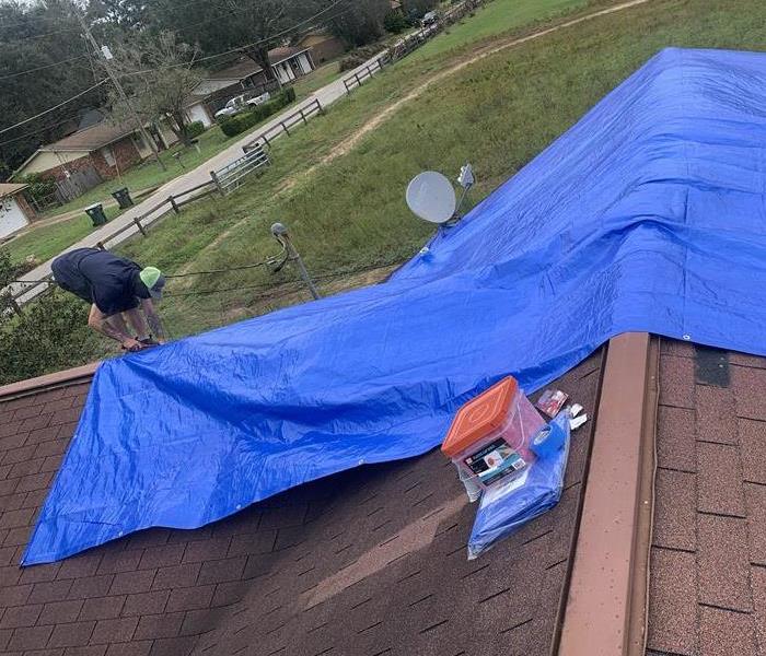 a roof that has been damaged partially covered in a tarp to prevent further internal damage 